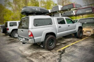 toyota tacoma with an are camper shell and a thule cargo hauler
